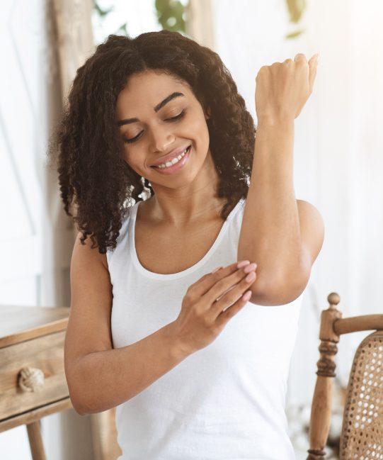 Black woman massaging skin.