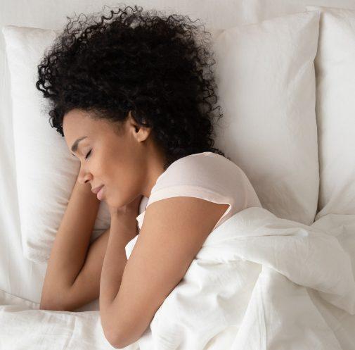 Black woman sleeping in bed.