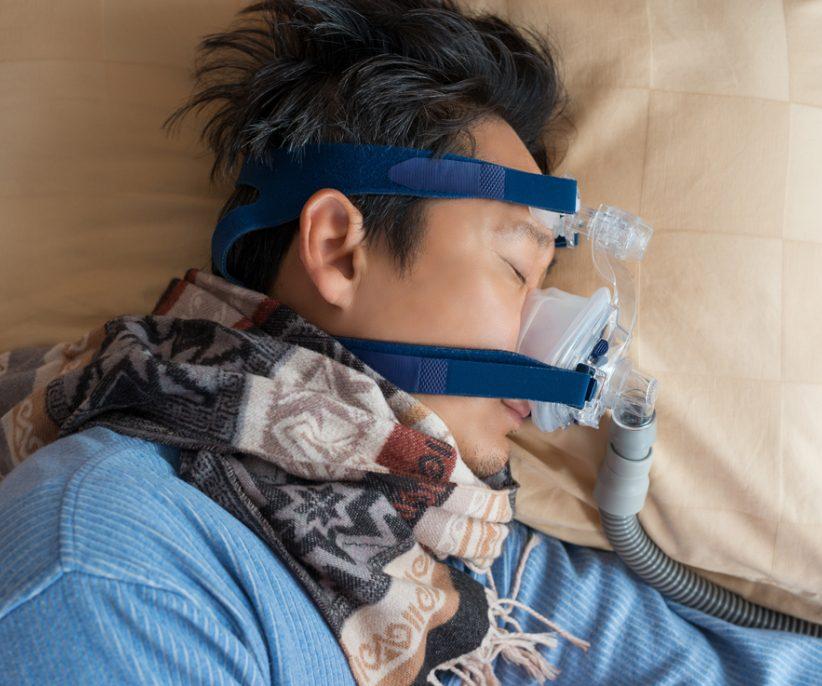 Asian man with sleep apnea mask.